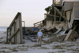 H.V. Bailey looks at damage to a neighbor's home at Ponte Vedra Beach, Fla., Saturday, Oct. 8, 2016, after Hurricane Matthew passed through Friday. (AP Photo/Charlie Riedel)