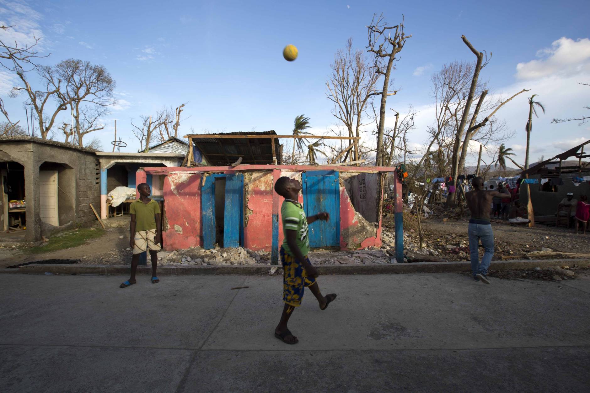 Boys play soccer in front of a house that was destroyed by Hurricane Matthew in Dame-Marie, Haiti, Monday, Oct. 10, 2016. Nearly a week after the storm smashed into southwestern Haiti, some communities along the southern coast have yet to receive any assistance, leaving residents who have lost their homes and virtually all of their belongings struggling to find shelter and potable water. (AP Photo/Dieu Nalio Chery)