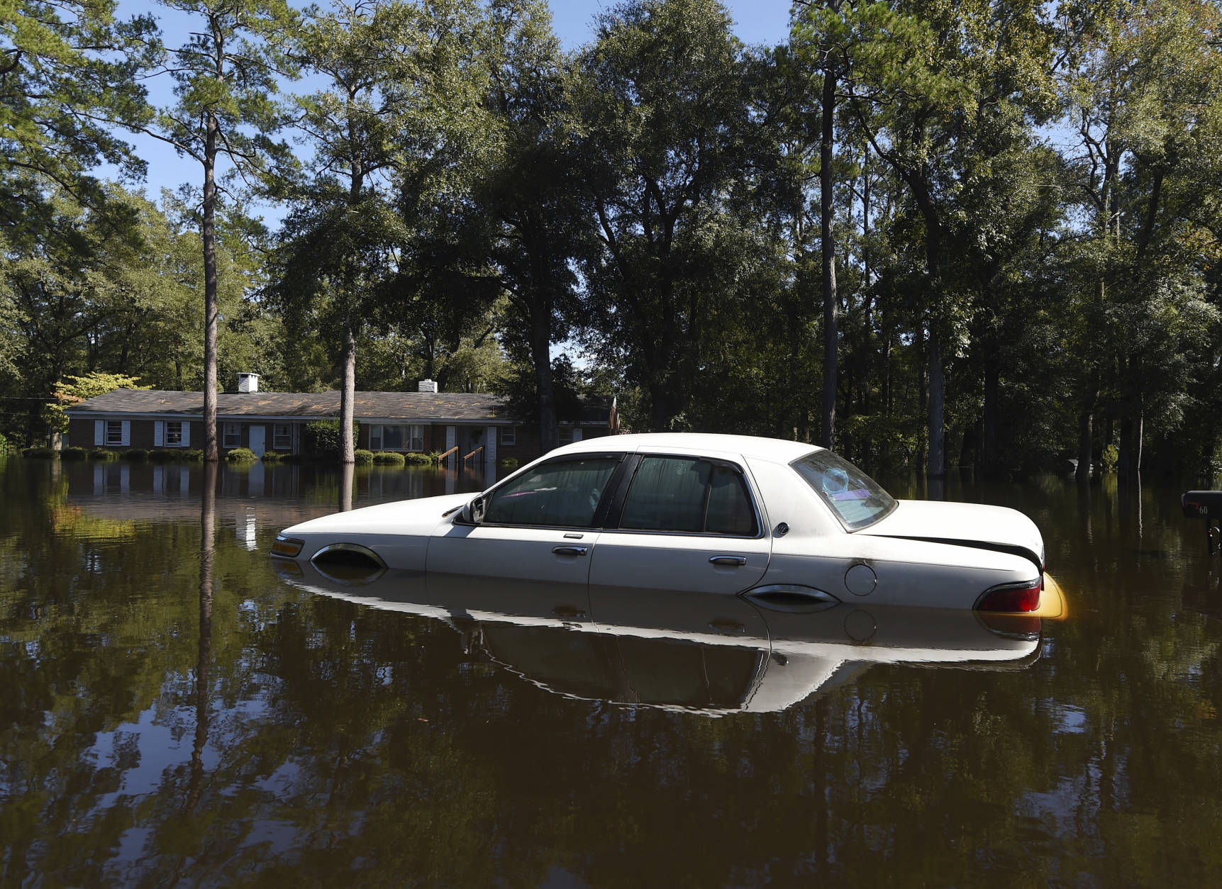 A car is surrounded by floodwaters on Highway 9, Tuesday, Oct. 11, 2016, in Nichols, S.C. About 150 people were rescued by boats from flooding in the riverside village of Nichols on Monday. (AP Photo/Rainier Ehrhardt)