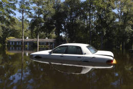 A car is surrounded by floodwaters on Highway 9, Tuesday, Oct. 11, 2016, in Nichols, S.C. About 150 people were rescued by boats from flooding in the riverside village of Nichols on Monday. (AP Photo/Rainier Ehrhardt)