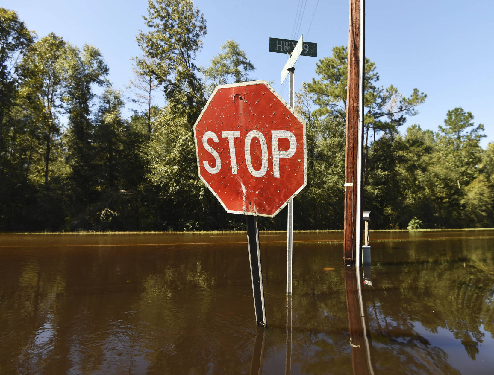 Floodwaters surround street signs on Highway 9, Tuesday, Oct. 11, 2016, in Nichols, S.C. About 150 people were rescued by boats from flooding in the riverside village of Nichols on Monday. (AP Photo/Rainier Ehrhardt)