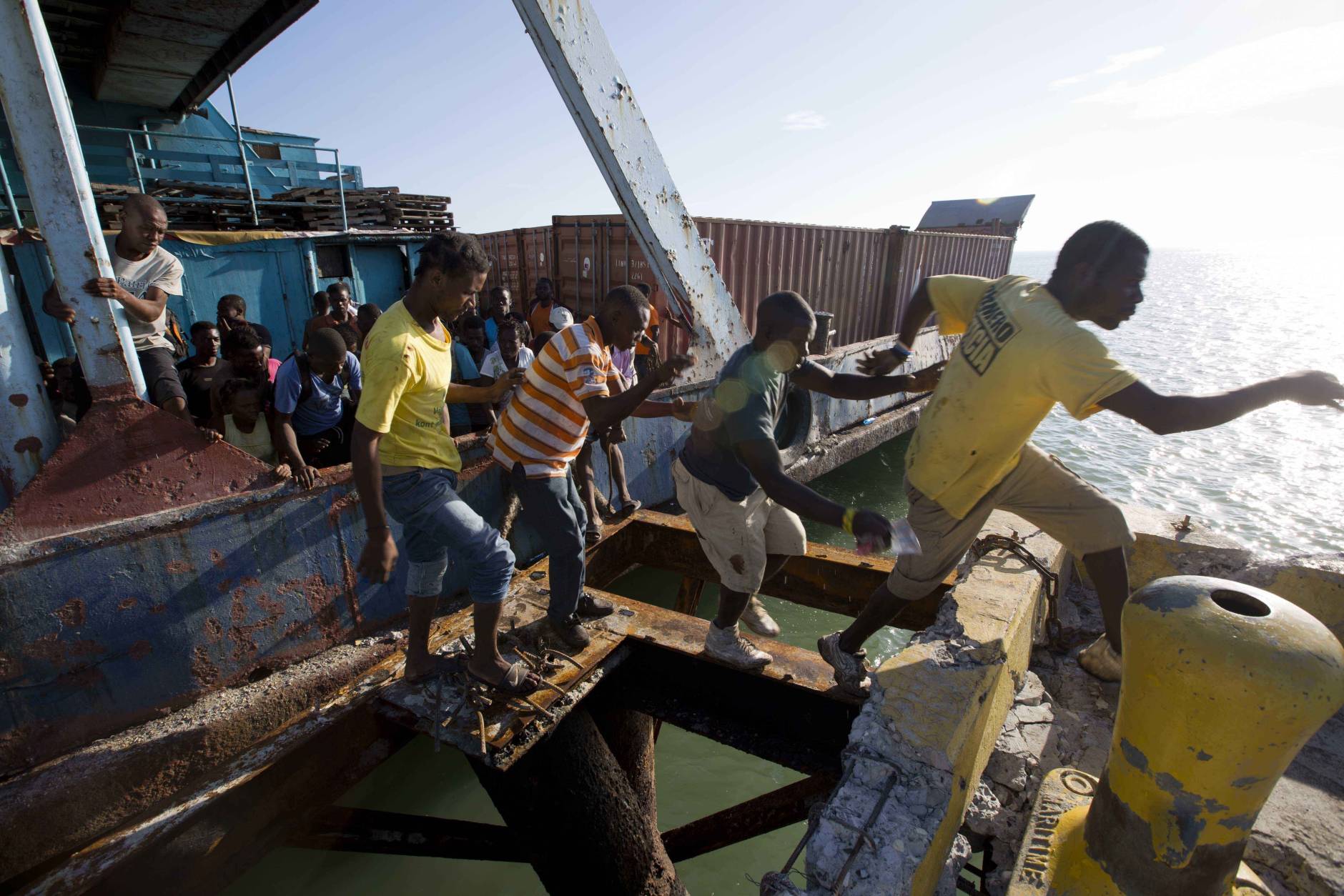People try to get off a boat carrying aid as national police arrive to secure the boat as it docks in Jeremie, Haiti, Wednesday, Oct. 12, 2016, in the aftermath of Hurricane Matthew. The U.N. envoy for Haiti says the impoverished Caribbean nation is facing "a humanitarian tragedy and an acute emergency situation" with 1.4 million people needing immediate help. (AP Photo/Dieu Nalio Chery)