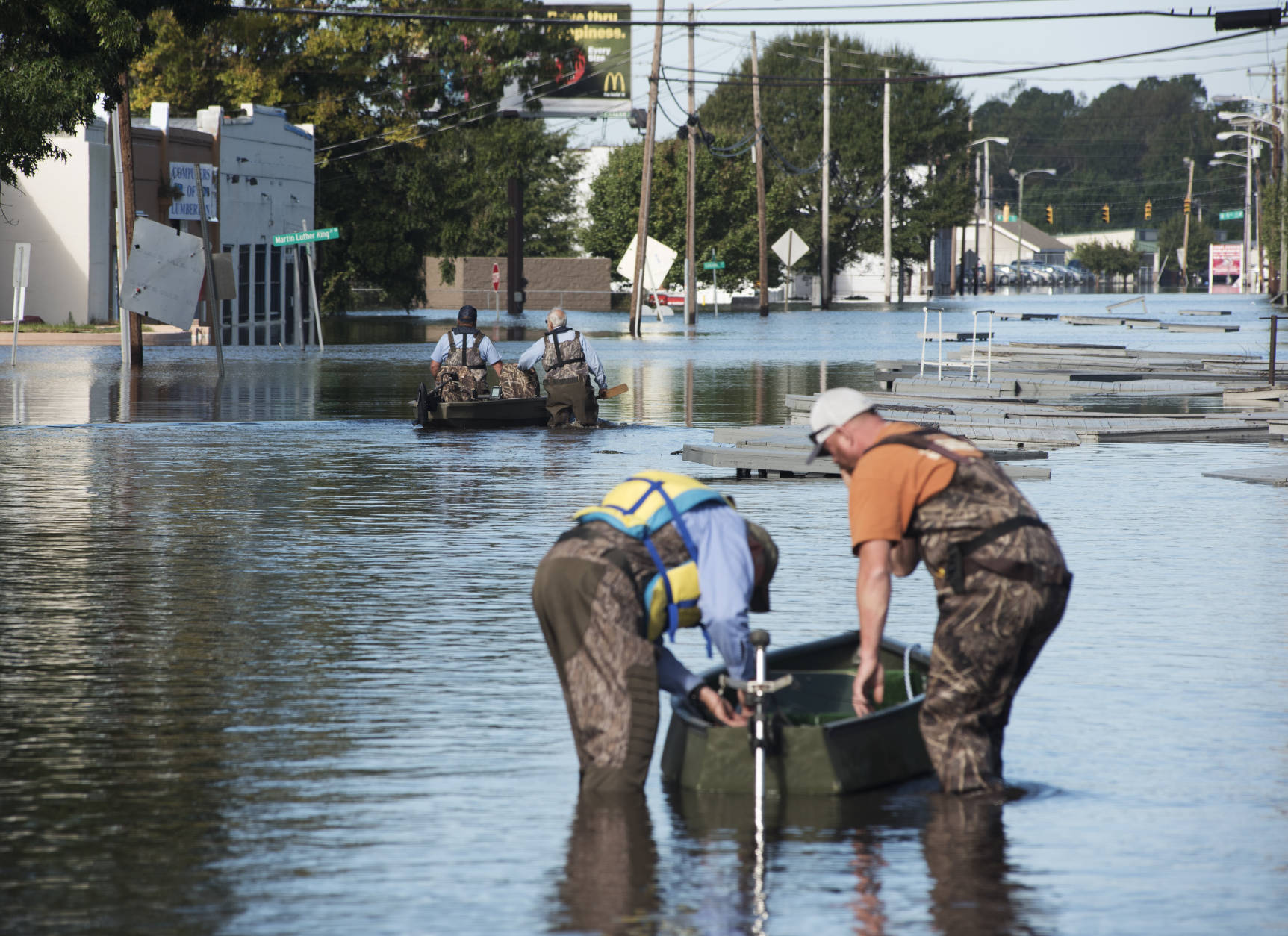 Workers with the City of Lumberton use boats to travel down West 5th Street to the city's water treatment plant through floodwaters caused by rain from Hurricane in Lumberton, N.C., Wednesday, Oct. 12, 2016. (AP Photo/Mike Spencer)
