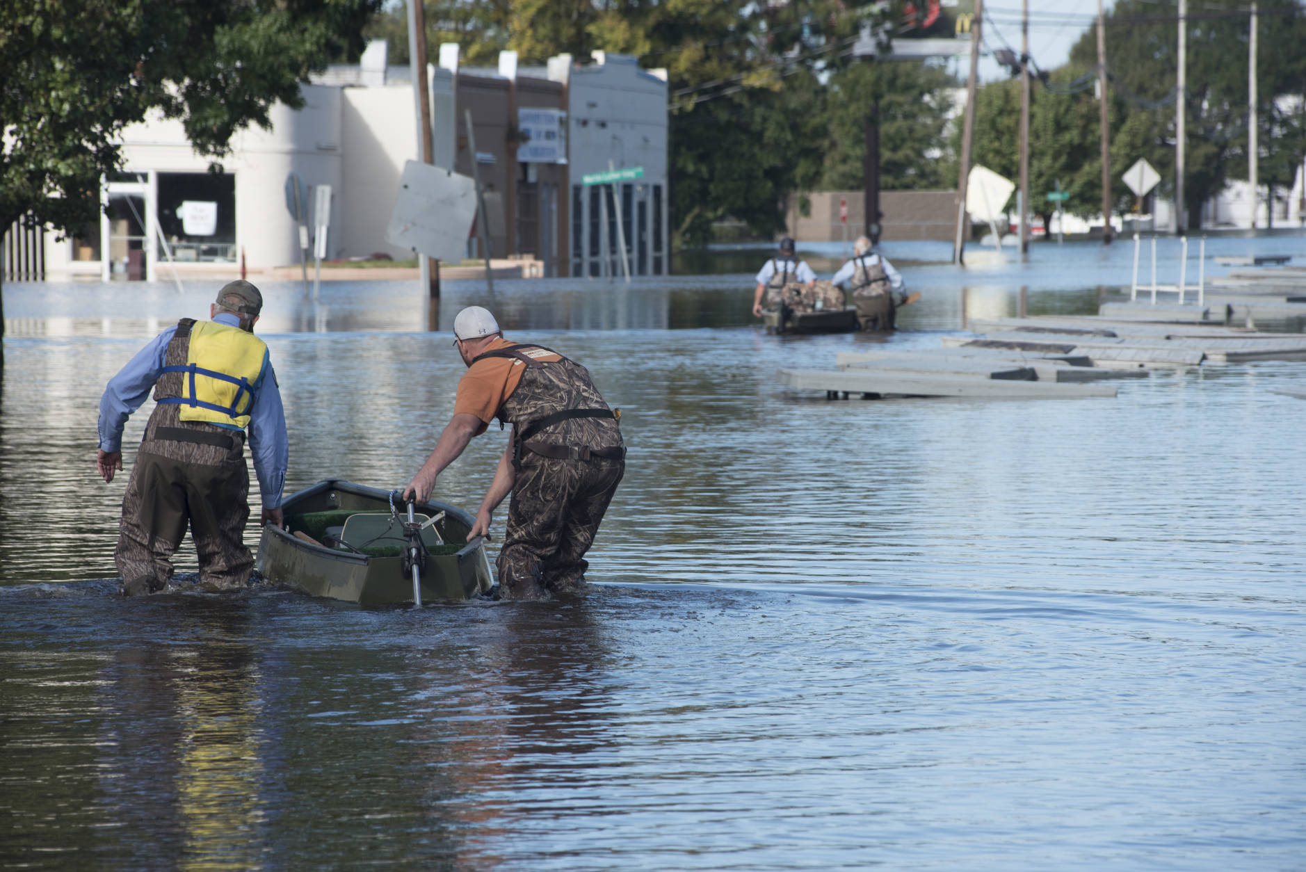 Workers with the City of Lumberton use boats to travel down West 5th Street to the cities water treatment plant through floodwaters caused by rain from Hurricane in Lumberton, N.C., Wednesday, Oct. 12, 2016. (AP Photo/Mike Spencer)
