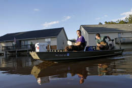 Kyle Hawley, right, and roommate Trey Wood, pilot their boat through the streets of their neighborhood, flooded by water associated with Hurricane Matthew, as they gather belongings from their home, Wednesday, Oct. 12, 2016, in Greenville, N.C. (AP Photo/Brian Blanco)