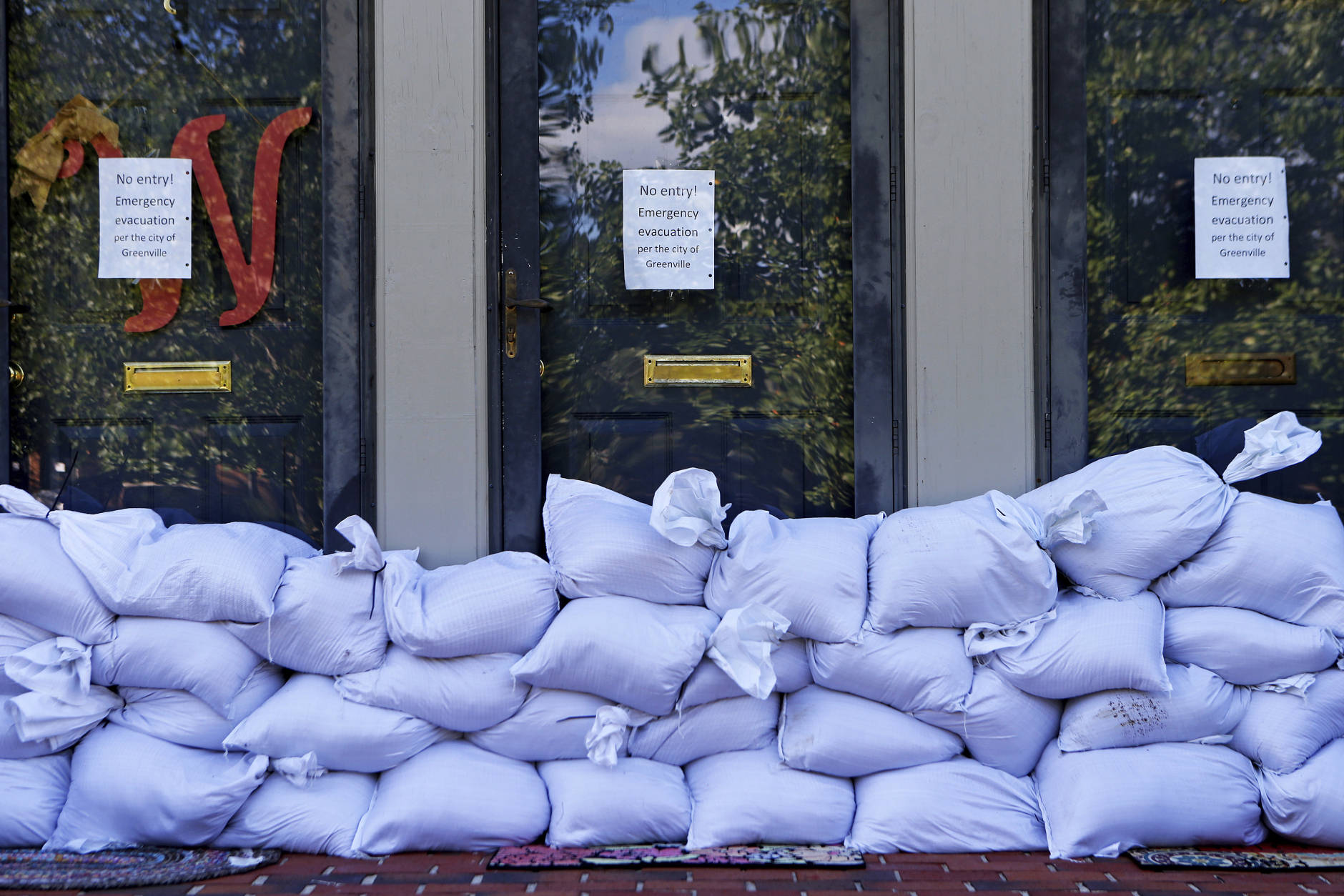 Sandbags and no entry signs are seen in front of apartments located near the Tar River as floodwaters associated with Hurricane Matthew continue to rise on Wednesday, Oct. 12, 2016, in Greenville, N.C. (AP Photo/Brian Blanco)