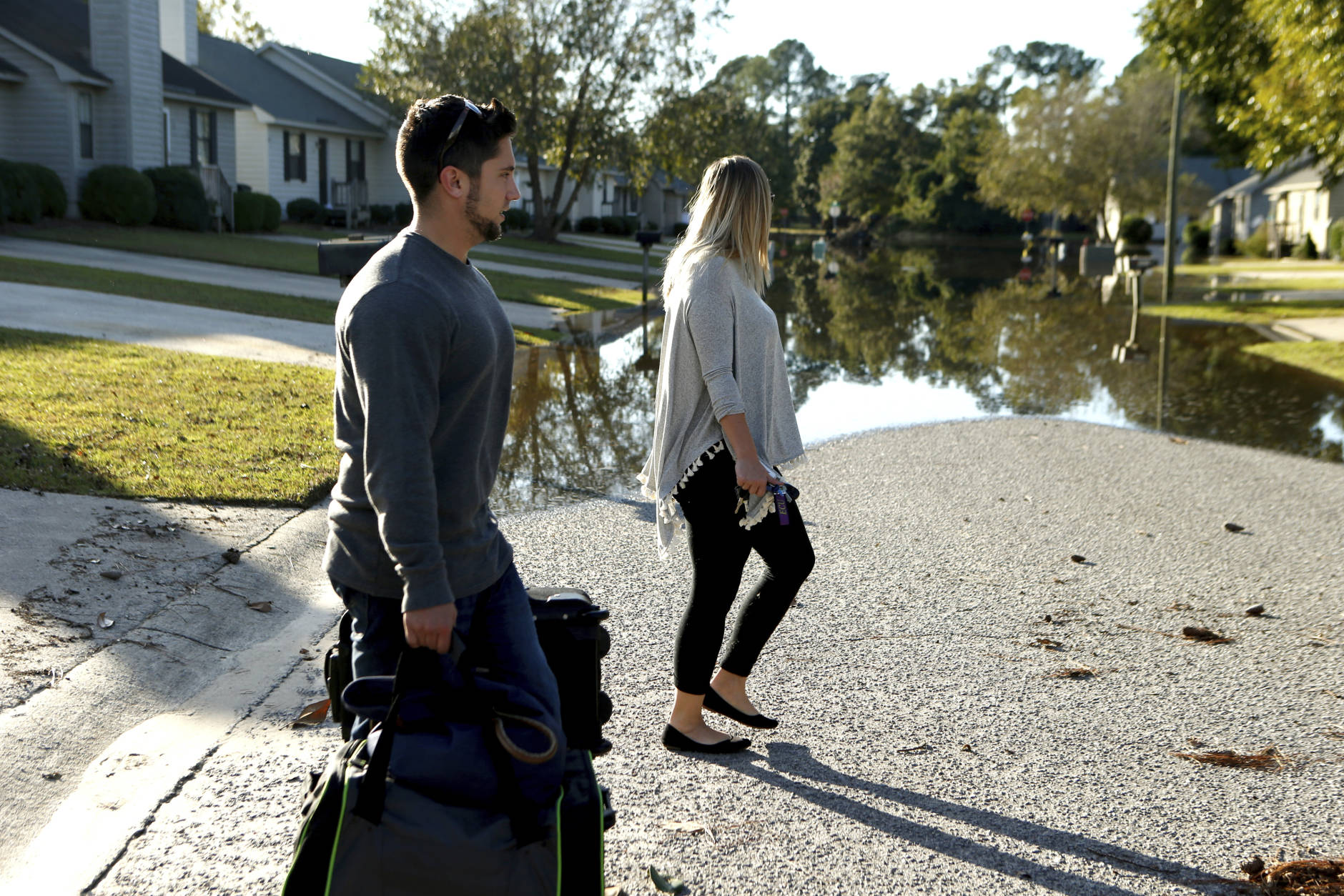 Collin Perry and Chelsea Blazer arrive from a vacation to find that, unlike several neighbors down the street, their home had not been impacted by floodwaters associated with Hurricane Matthew residents inspect flooding along the Tar River, Wednesday, Oct. 12, 2016, in Greenville, N.C. (AP Photo/Brian Blanco)