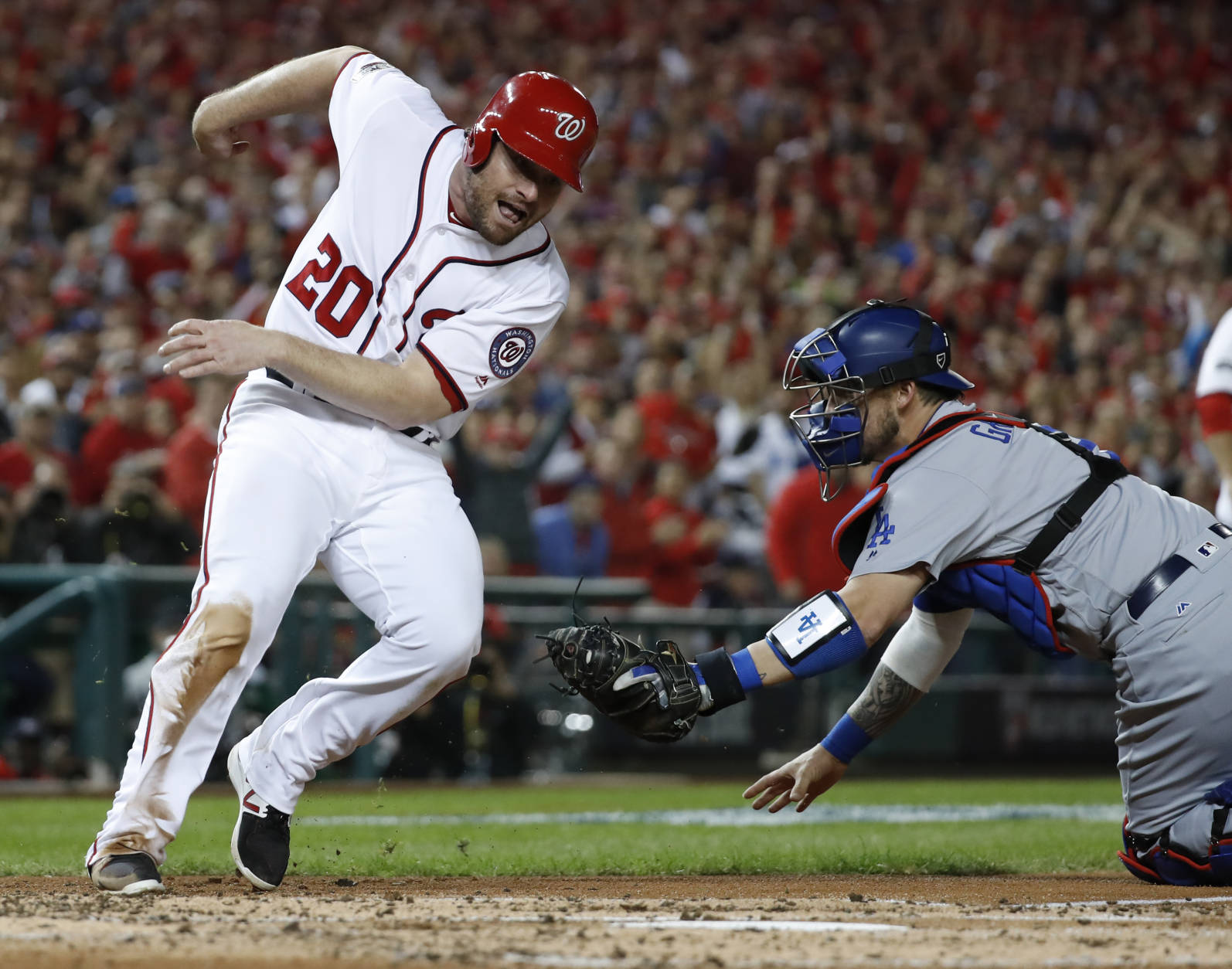 Washington Nationals' Daniel Murphy (20) runs around the tag from Los Angeles Dodgers catcher Yasmani Grandal (9) to score during the second inning in Game 5 of baseball's National League Division Series, at Nationals Park, Thursday, Oct. 13, 2016, in Washington. (AP Photo/Alex Brandon)