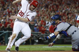 Washington Nationals' Daniel Murphy (20) runs around the tag from Los Angeles Dodgers catcher Yasmani Grandal (9) to score during the second inning in Game 5 of baseball's National League Division Series, at Nationals Park, Thursday, Oct. 13, 2016, in Washington. (AP Photo/Alex Brandon)