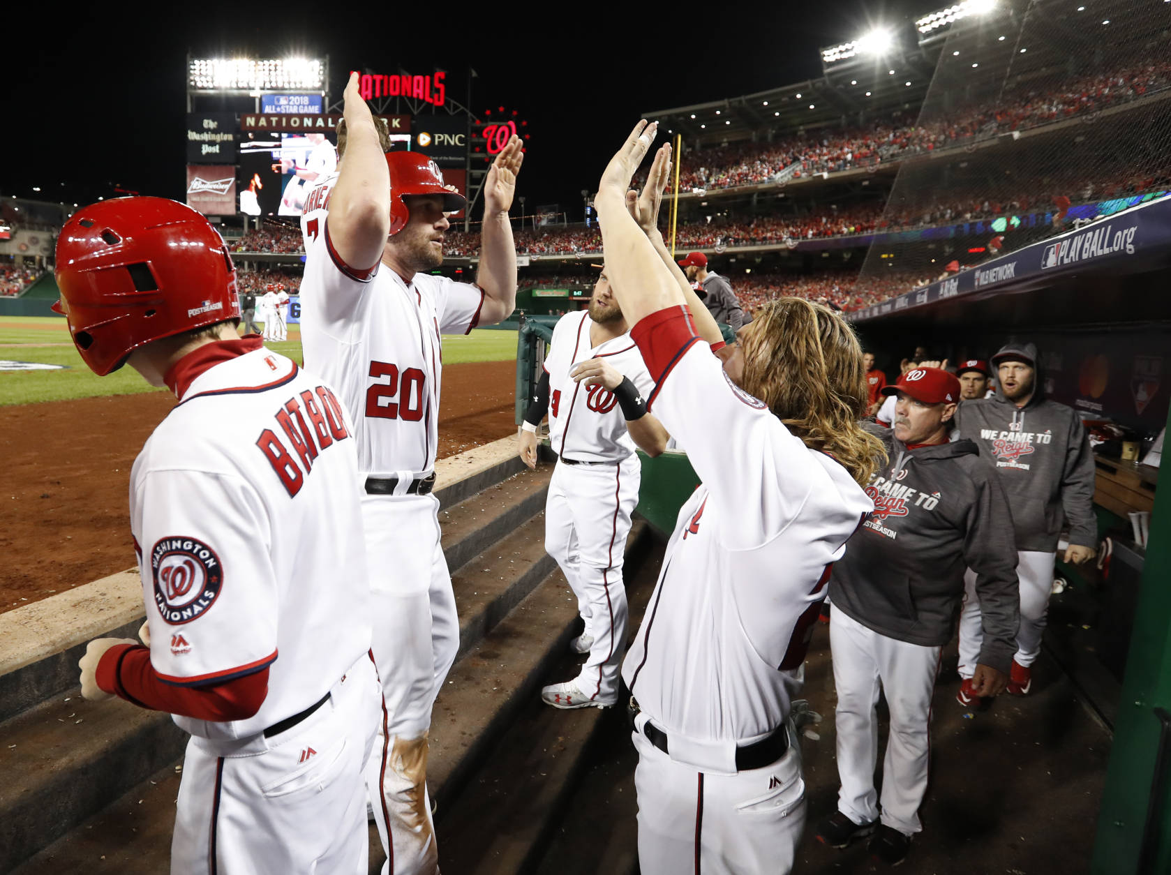 Washington Nationals' Daniel Murphy (20) celebrates in the dugout with teammates Jayson Werth (28) and Bryce Harper (34) after scoring during the second inning in Game 5 of baseball's National League Division Series against Los Angeles Dodgers, at Nationals Park, Thursday, Oct. 13, 2016, in Washington. (AP Photo/Alex Brandon)