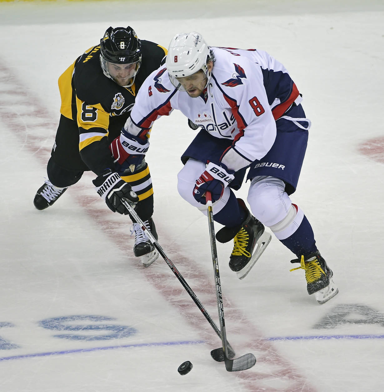 Pittsburgh Penguins defenseman Brian Dumoulin, left, and Washington Capitals left wing Alex Ovechkin (8) reach for the puck during the third period of an NHL hockey game Thursday, Oct. 13, 2016, in Pittsburgh. (AP Photo/Fred Vuich)