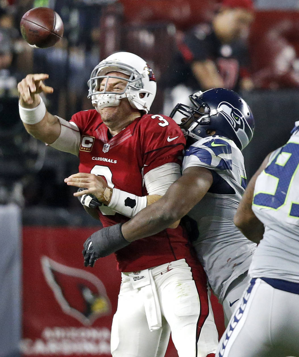 Arizona Cardinals quarterback Carson Palmer (3) his hit as he throws by Seattle Seahawks defensive tackle Ahtyba Rubin during the second half of a football game, Sunday, Oct. 23, 2016, in Glendale, Ariz. (AP Photo/Ross D. Franklin)