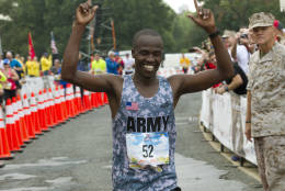 Samuel Kosgei, from Junction City, Kan., crosses the finish line, the first male finisher of the 41st Marine Corps Marathon, Sunday, Oct. 30, 2016 in Arlington, Va. The race includes runners from 55 nations and each branch of the U.S. armed forces. ( AP Photo/Jose Luis Magana)