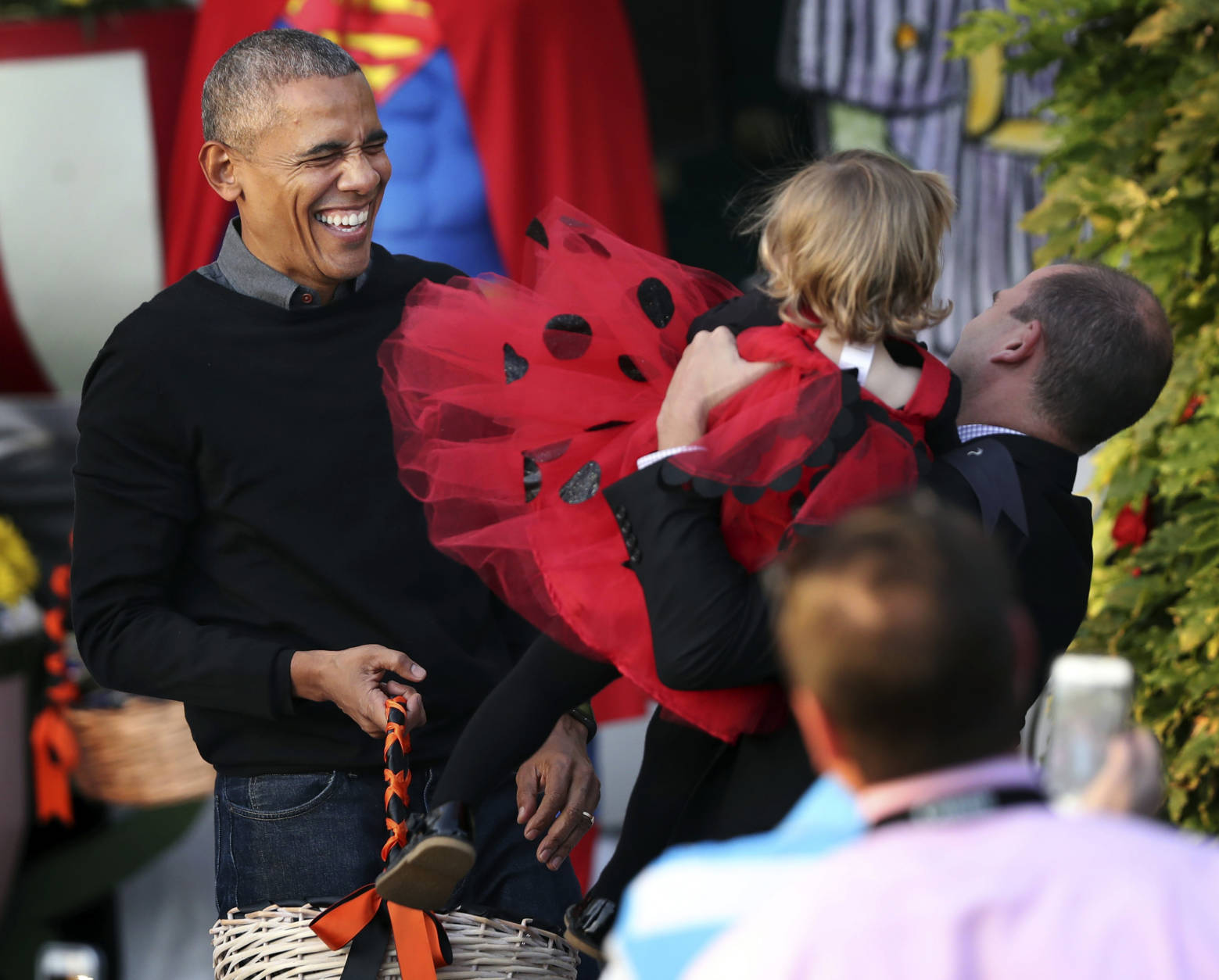 President Barack Obama laughs as he hands treats to children from Washington area and children of military families during a trick-or-treat celebrating Halloween at the South Portico of the White House in Washington, Monday, Oct. 31, 2016. (AP Photo/Manuel Balce Ceneta)