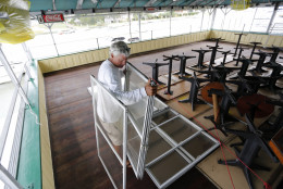 Bob Wilder, an employee at Morgan Creek Grill, moves windows from the third floor bar at the popular restaurant on the Isle of Palms, S.C., Wednesday, Oct. 5, 2016, in advance of Hurricane Matthew. Hurricane Matthew is expected to affect the South Carolina coast by the weekend. Gov. Nikki Haley announced Tuesday that, unless the track of the storm changes, the state will issue an evacuation order Wednesday to help get 1 million people inland from the coast. (AP Photo/Mic Smith)