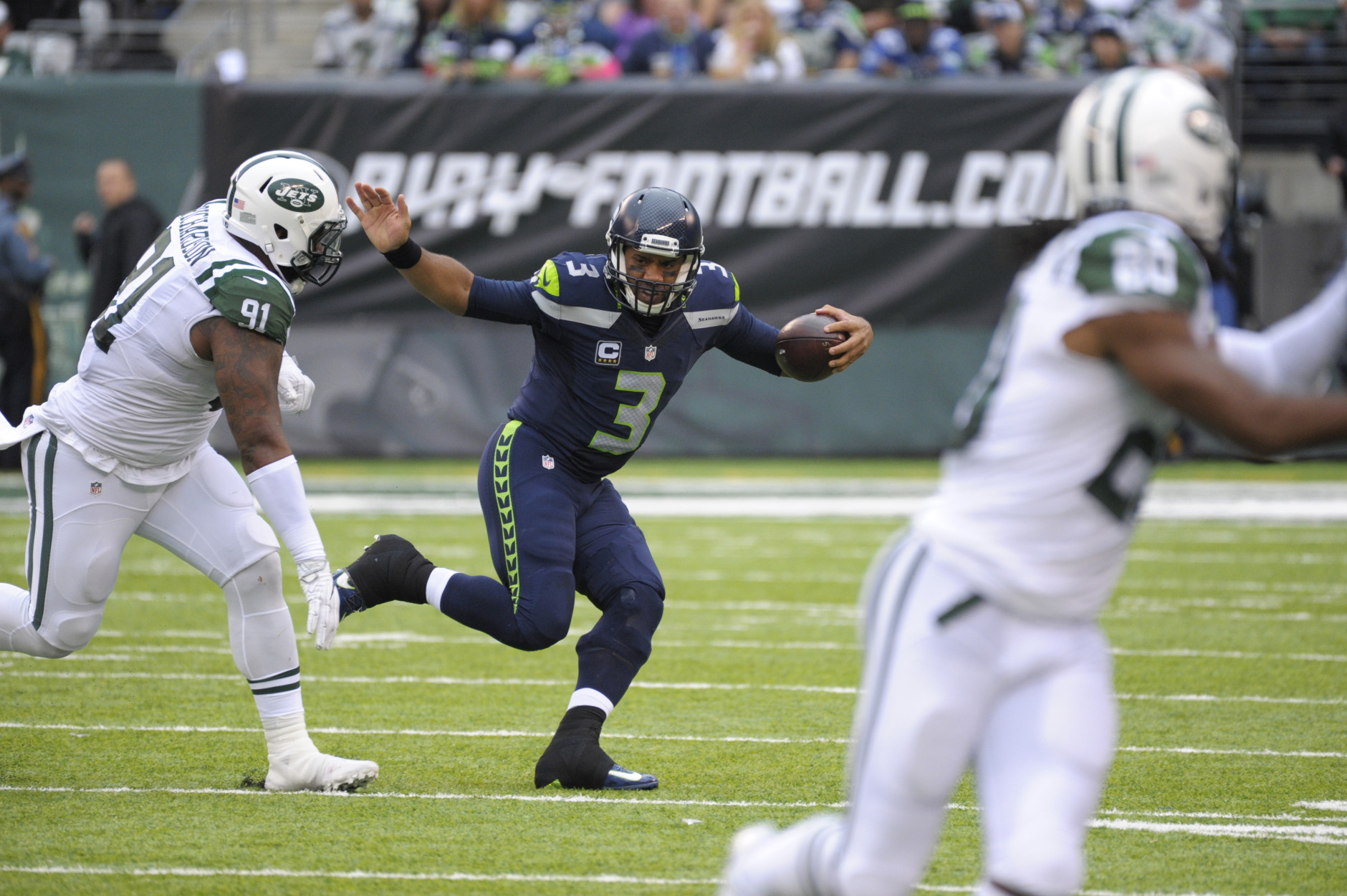 Seattle Seahawks quarterback Russell Wilson (3) runs away from New York Jets' Sheldon Richardson (91) during the second half of an NFL football game Sunday, Oct. 2, 2016, in East Rutherford, N.J.  (AP Photo/Bill Kostroun)