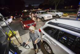Gayle Brown fills up her car after waiting in line at a Sunoco gas station in Mt. Pleasant, S.C., Tuesday, October 4, 2016 in advance of Hurricane Matthew which is expected to affect the South Carolina coast by the weekend. Gov. Nikki Haley announced Tuesday that, unless the track of the storm changes, the state will issue an evacuation order Wednesday to help get 1 million people inland from the coast. "Never going to happen again after Hurricane Floyd", Brown said after she experienced nightmare traffic while evacuating from Hurricane Floyd several years ago.  (AP Photo/Mic Smith)