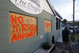 Jim Van Tiem walks out of The Dinghy as the popular restaurant is boarded up with a message to Hurricane Matthew on the Isle of Palms, S.C., Wednesday, Oct. 5, 2016.  (AP Photo/Mic Smith)