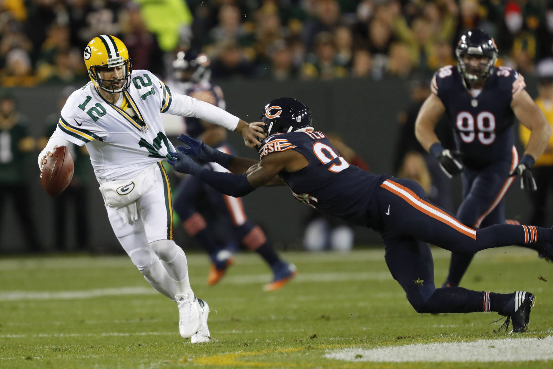 Green Bay Packers quarterback Aaron Rodgers (12) tries to runs away from Chicago Bears outside linebacker Leonard Floyd (94) during the first half of an NFL football game, Thursday, Oct. 20, 2016, in Green Bay, Wis. (AP Photo/Matt Ludtke)