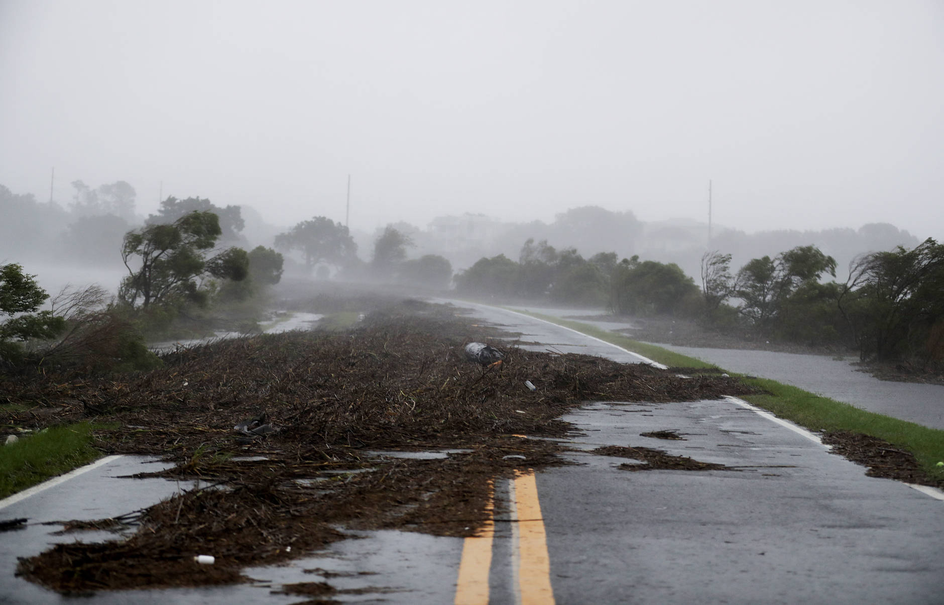 Debris litters a road after it washed over from Hurricane Matthew on St. Simons Island, Ga., Friday, Oct. 7, 2016. (AP Photo/David Goldman)