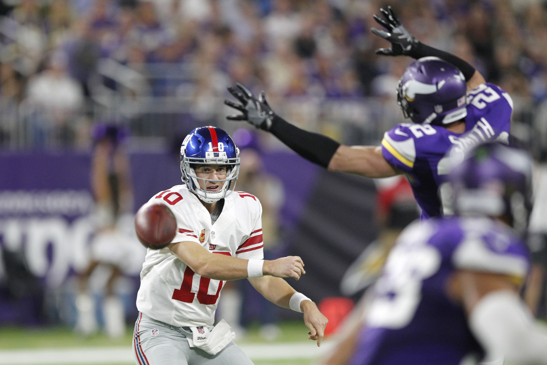 New York Giants quarterback Eli Manning, left, throws a pass around Minnesota Vikings free safety Harrison Smith (22) during the first half of an NFL football game Monday, Oct. 3, 2016, in Minneapolis. (AP Photo/Andy Clayton-King)