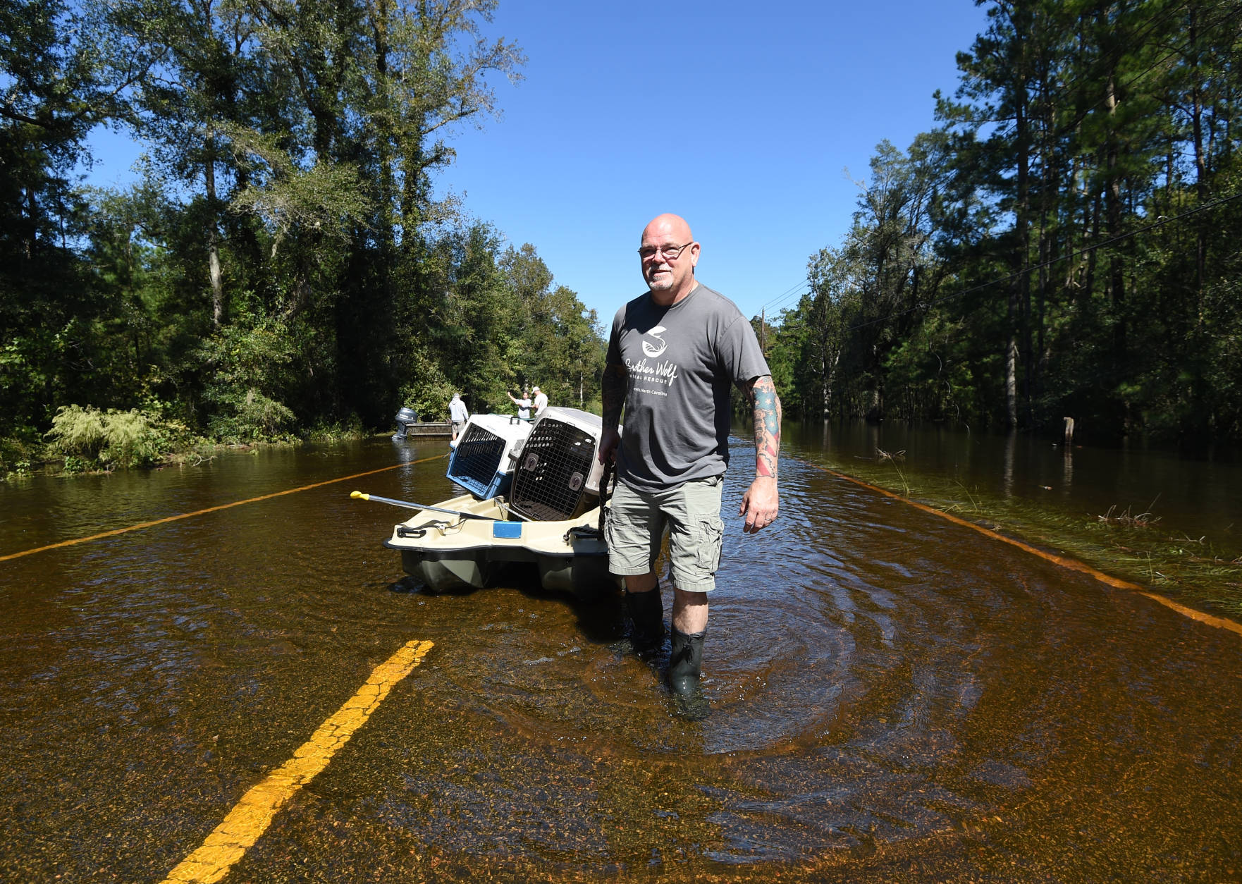 Tom Chickos, of Ashville, N.C. with Brother Wolf Animal Rescue, pulls a boat with kennels down Highway 9 on Tuesday, Oct. 11, 2016, in Nichols, S.C. About 150 people were rescued by boats from flooding in the riverside village of Nichols on Monday. (AP Photo/Rainier Ehrhardt)
