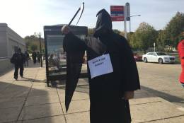 A costumed rallier outside Southern Avenue Metro station echoes the "death spiral" theme. In addition to proposed layoffs, union members are also concerned over cuts to worker benefits. (WTOP/Max Smith)