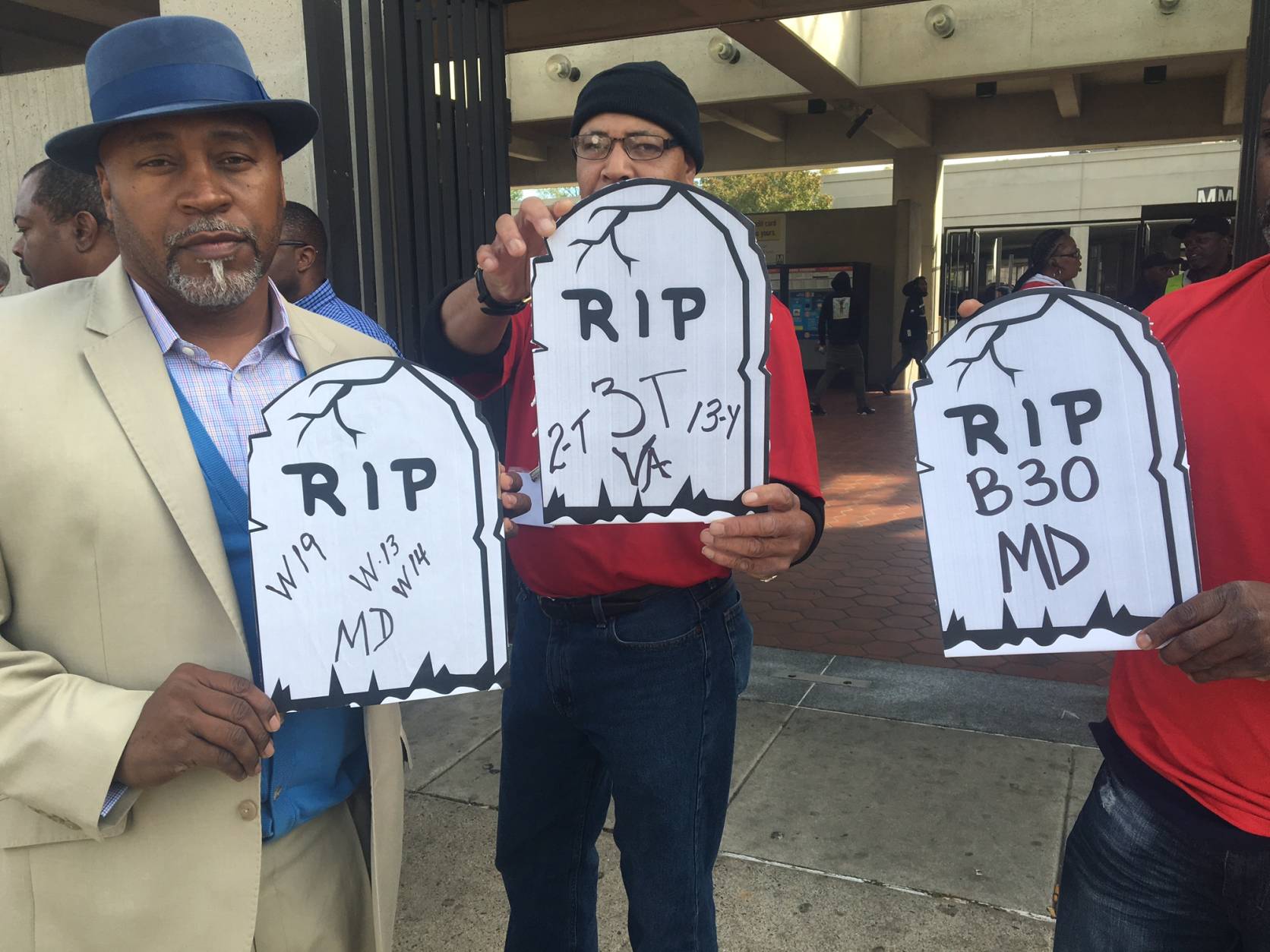 Members of Metro's largest union, Amalgamated Transit Union Local 689 hold up "grave stones" during a rally on Monday, Oct. 31, 2016 outside Southern Avenue Metro station in Prince George's County, Md. (WTOP/Max Smith)