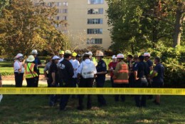 Emergency responders gather outside of the River Towers condo in Alexandria, Va. The nine-story building was evacuated on Sunday, Oct. 2, 2016, due to possible structural damage. (WTOP/Dick UIiano)