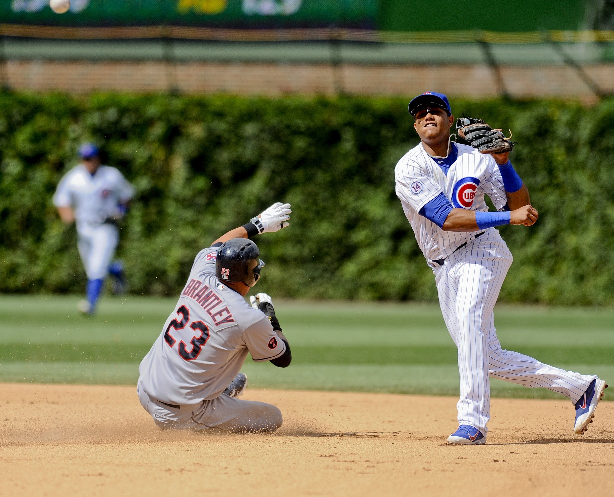 Chicago Cubs shortstop Starlin Castro (13) completes a double play after forcing Cleveland Indians' Michael Brantley (23) out at second base during the seventh inning of a baseball game  on Monday, Aug. 24, 2015, in Chicago. (AP Photo/Matt Marton)