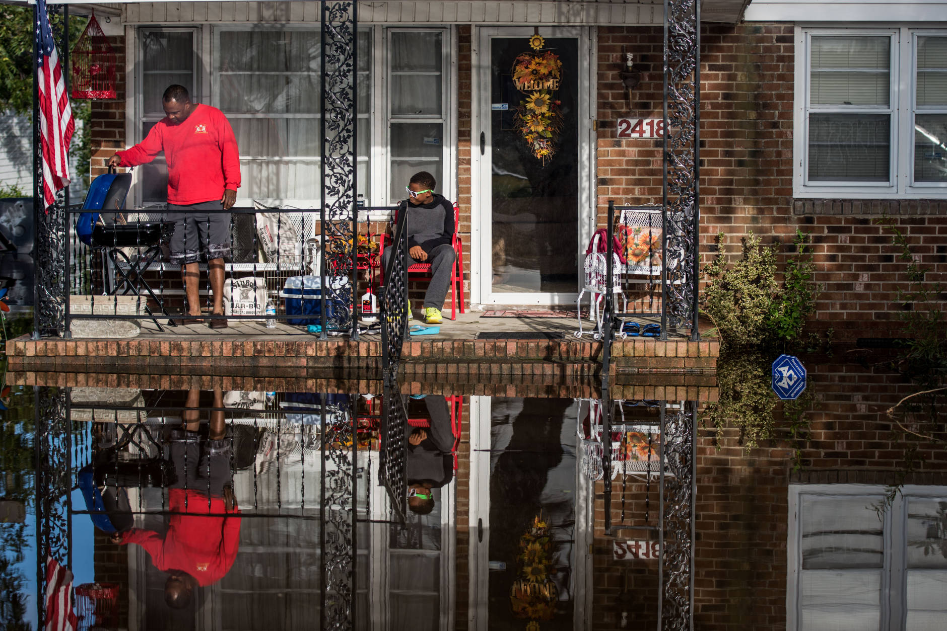 LUMBERTON, NC - OCTOBER 12: Robert Addison, left cooks breakfast on a charcoal grill with his son, Artis Addison, on October 12, 2016 in Lumberton, North Carolina. Hurricane Matthew's heavy rains ended over the weekend, but flooding is still expected for days in North Carolina. (Photo by Sean Rayford/Getty Images)