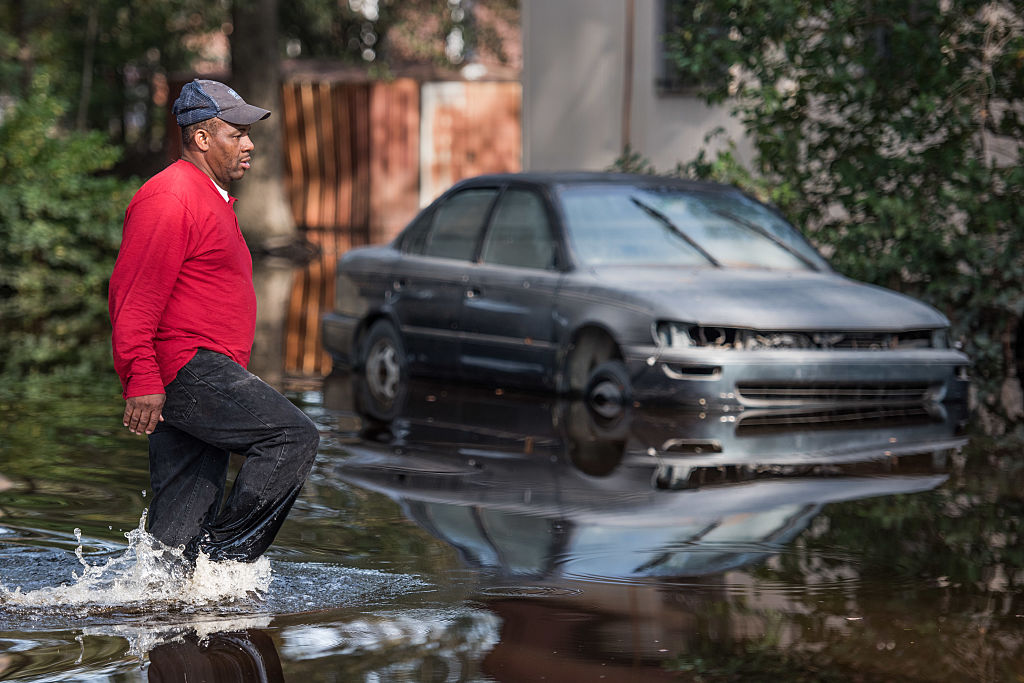 LUMBERTON, NC - OCTOBER 15: Stefone Cromartie walks down a flooded street towards his home on October 15, 2016 in Lumberton, North Carolina. The flooding caused by Hurricane Matthew has been responsible for 26 deaths in the state. (Photo by Sean Rayford/Getty Images)
