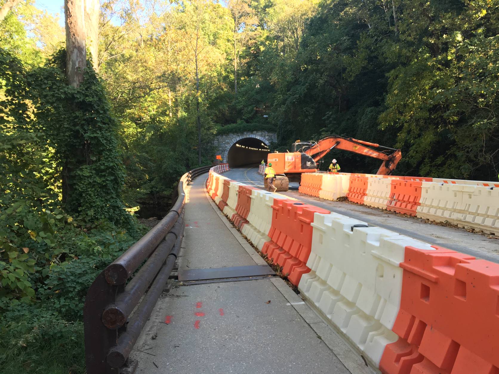In the southern work zone, crews have begun to rip up pavement, replace the railing on a bridge and put new pipes and manhole casings in deeply-dug trenches. (WTOP/Max Smith)