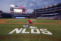Washington Nationals field manager Matt Coates paints the NLDS logo on the field at Nationals Park, Thursday, Oct. 6, 2016, in Washington. The Nationals host the Los Angeles Dodgers in Game 1 of baseball's National League Division Series on Friday. (AP Photo/Alex Brandon)