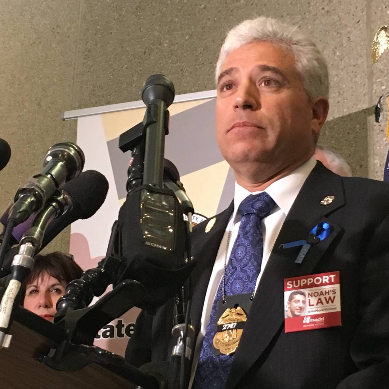 Noah Leotta's dad, Rich speaks Thursday. His wife, Marcia can be seen obstructed by microphones. (WTOP/Kate Ryan)