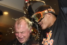 Baltimore Orioles manager Buck Showalter is doused with beer by Manny Machado in the visitors' clubhouse after the Orioles defeated the New York Yankees 5-2 in a baseball game to go to the playoffs , Sunday, Oct. 2, 2016, in New York. (AP Photo/Kathy Kmonicek)