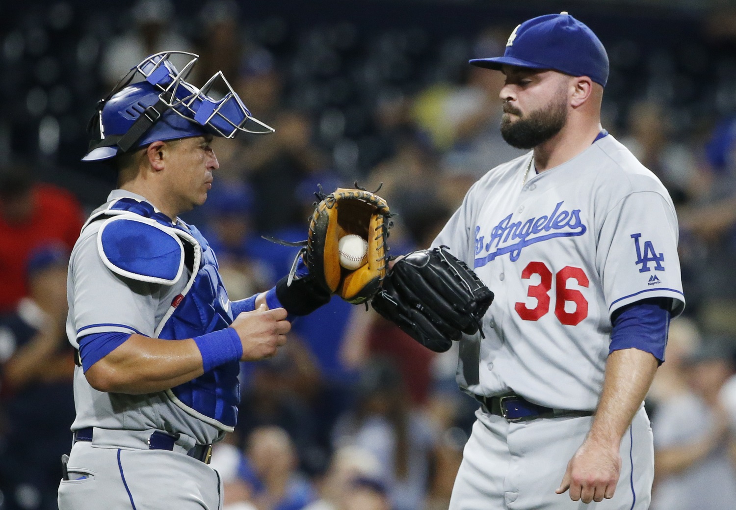 Los Angeles Dodgers relief pitcher Adam Liberatore and catcher Carlos Ruiz bump gloves after the Dodgers' 9-4 victory over the San Diego Padres in a baseball game Thursday, Sept. 29, 2016, in San Diego. (AP Photo/Lenny Ignelzi)