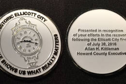 Each "flood hero" received two coins, including this one, shown with both sides in this photo, from Howard County Executive Allan Kittleman. (WTOP/Michelle Basch)
