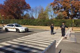 Police officers have replaced public safety aides on the road leading to the cemetery. (WTOP/John Aaron)