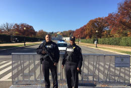 Police officers have replaced public safety aides on the road leading to the cemetery. (WTOP/John Aaron)