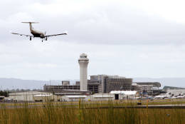 FILE - In this July 13, 2014, file photo, a plane lands at Portland International Airport in Portland, Ore. Portland International Airport had a record four perimeter fence breaches in 2015, including one instance in which a person scrambled over the fence to avoid being hit by gang gunfire. In three other 2015 breaches, people crashed their cars into the fence; in June, after driving through a fence, the driver and passenger fled and were later arrested. Last year saw a big jump in security breaches at Portland, which has five others going back to 2004. (AP Photo/Don Ryan, File)