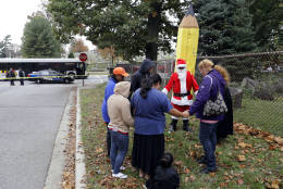 People pray near the scene of an early morning fatal collision between a school bus and a commuter bus in Baltimore, Tuesday, Nov. 1, 2016.  Baltimore police spokesman T.J. Smith said the school bus rear ended a car Tuesday morning, then struck a pillar at a cemetery and veered into oncoming traffic, hitting the Maryland Transit Administration bus on the driver's side. (AP Photo/Patrick Semansky)