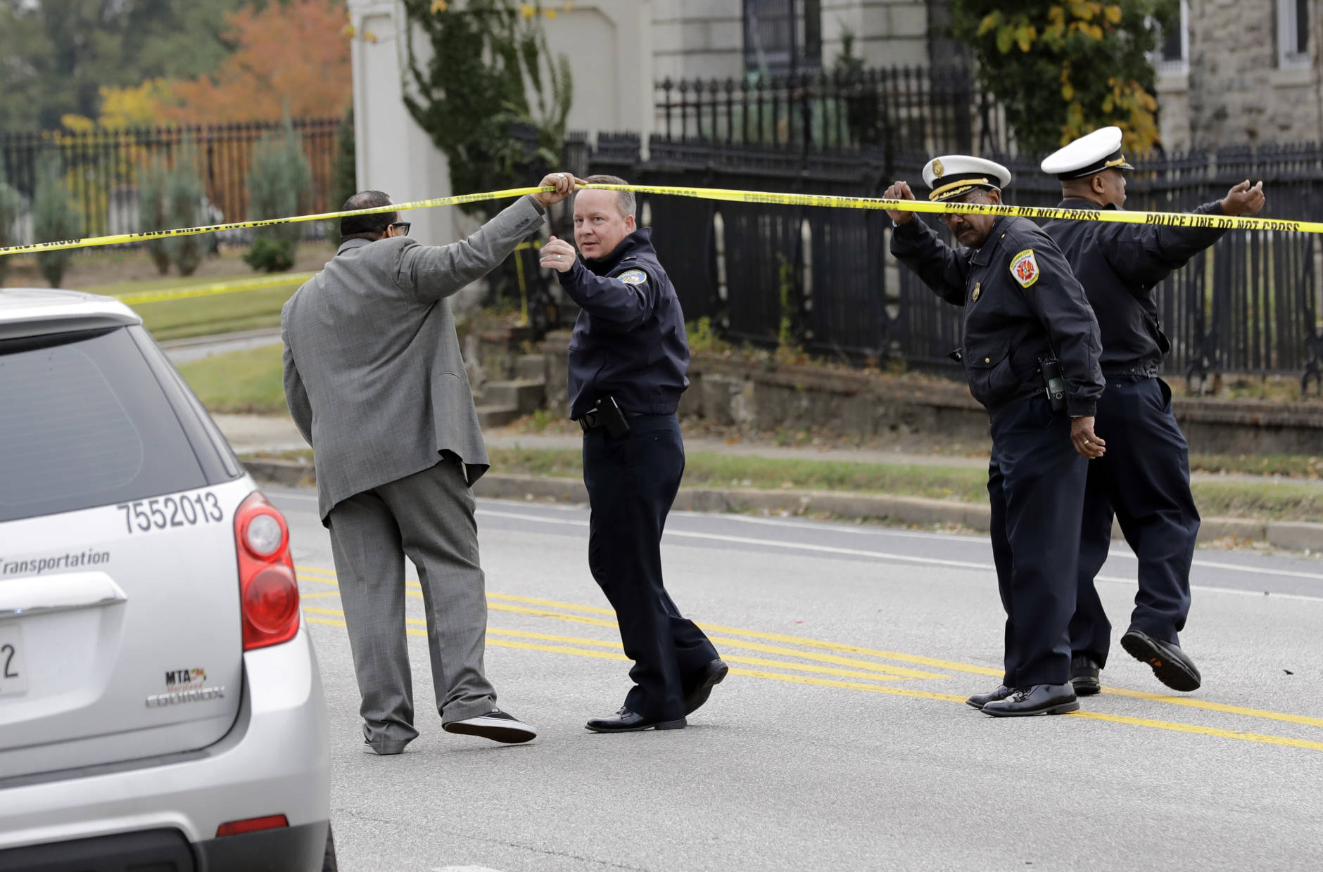 Baltimore Police Department commissioner Kevin Davis, second from left, approaches the scene of an early morning fatal collision between a school bus and a commuter bus in Baltimore, Tuesday, Nov. 1, 2016.  Baltimore police spokesman T.J. Smith said the school bus rear ended a car Tuesday morning, then struck a pillar at a cemetery and veered into oncoming traffic, hitting the Maryland Transit Administration bus on the driver's side.  (AP Photo/Patrick Semansky)