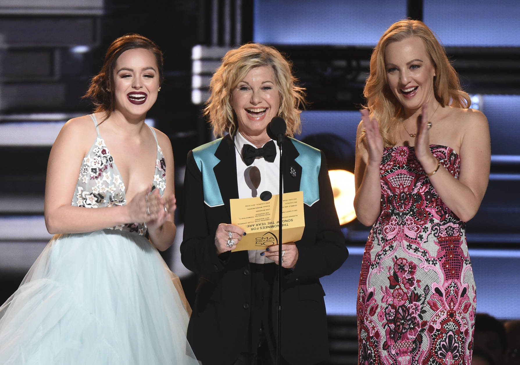 Hayley Orrantia, from left, Olivia Newton-John and Wendi McLendon-Covey and present the award for song of the year at the 50th annual CMA Awards at the Bridgestone Arena on Wednesday, Nov. 2, 2016, in Nashville, Tenn. (Photo by Charles Sykes/Invision/AP)