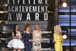 Dolly Parton accepts the Willie Nelson Lifetime Achievement Award at the 50th annual CMA Awards at the Bridgestone Arena on Wednesday, Nov. 2, 2016, in Nashville, Tenn. Looking on from left are Kacey Musgraves, Reba McEntire and Jennifer Nettles. (Photo by Charles Sykes/Invision/AP)