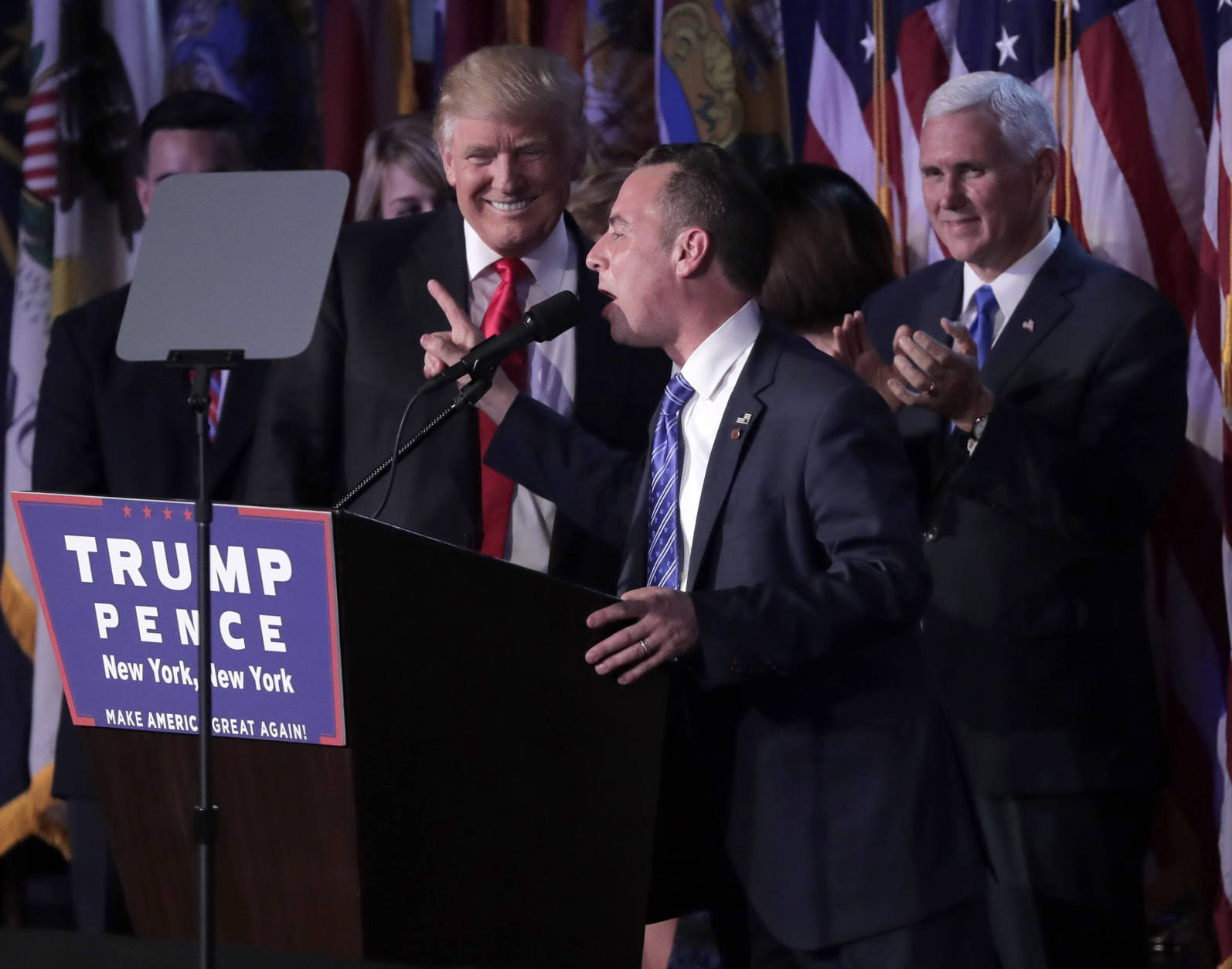 Reince Priebus, Chair of the Republican National Committee, right, speaks as President-elect Donald Trump gives his acceptance speech during his election night rally, Wednesday, Nov. 9, 2016, in New York. (AP Photo/Julie Jacobson)