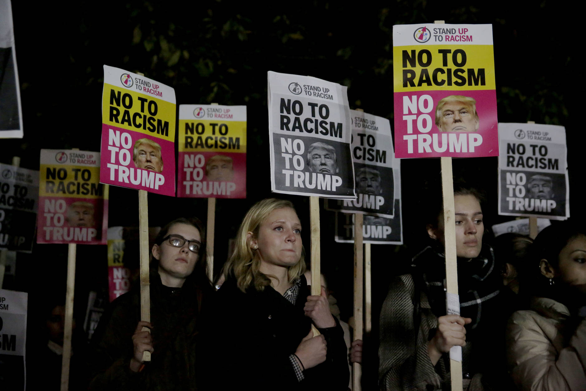 People hold placards as they take part in an anti-racism protest against President-elect Donald Trump winning the American election, outside the U.S. embassy in London, Wednesday, Nov. 9, 2016. Democratic presidential candidate Hillary Clinton conceded her defeat to Republican Donald Trump after the hard-fought presidential election. (AP Photo/Matt Dunham)
