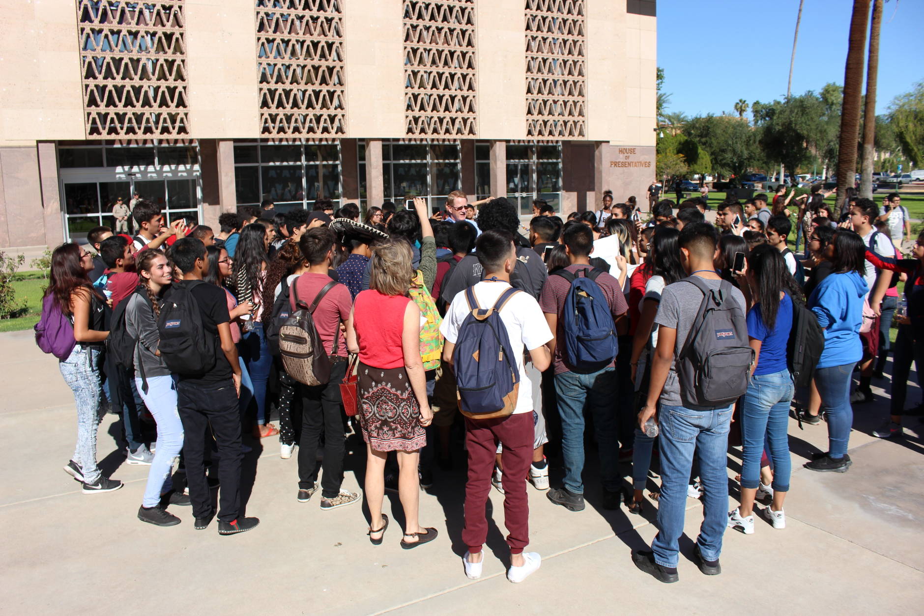 Arizona Department of Public Safety Capt. Ed Sharpensteen, center, speaks to high school students protesting Donald Trump's election at the state Capitol in Phoenix on Wednesday, Nov. 9, 2016. Students from several Phoenix high schools staged a walkout to protest Donald Trump's presidential victory. (AP Photo/Bob Christie)