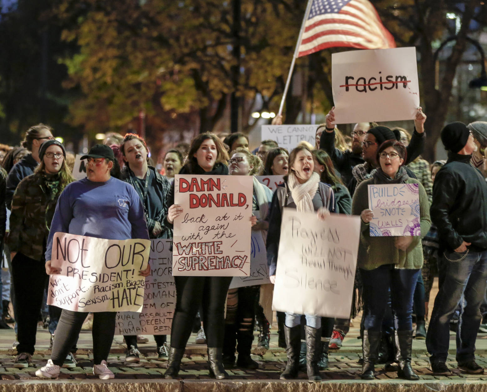 Demonstrators wave signs during a protest in downtown Omaha, Neb., Friday, Nov. 11, 2016, against the election of Donald Trump as President. (AP Photo/Nati Harnik)