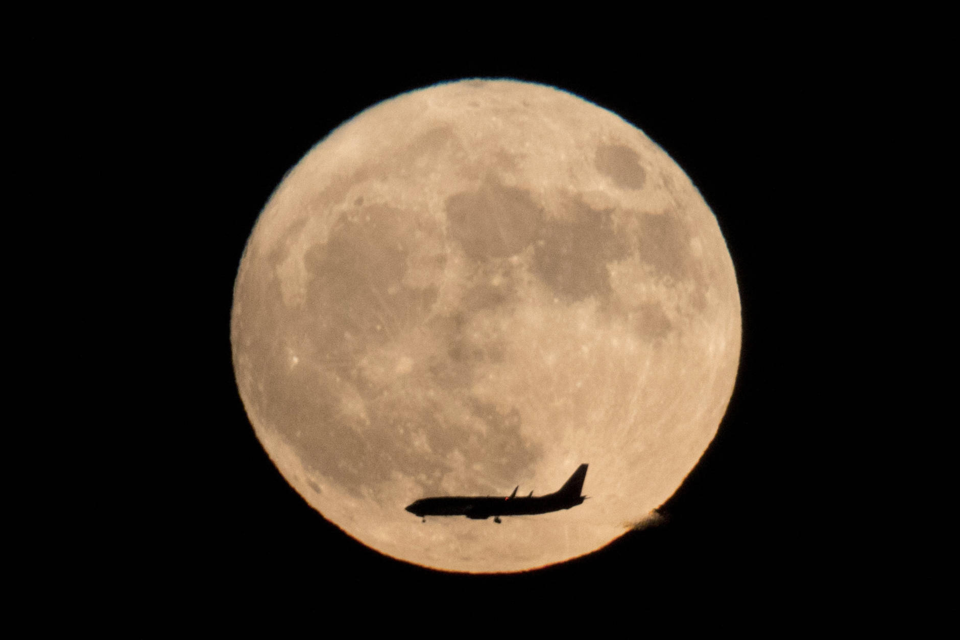 A jet plane flies across the moon seen from Beijing, China, Monday, Nov. 14, 2016. The brightest moon in almost 69 years will be lighting up the sky this week in a treat for star watchers around the globe. (AP Photo/Ng Han Guan)